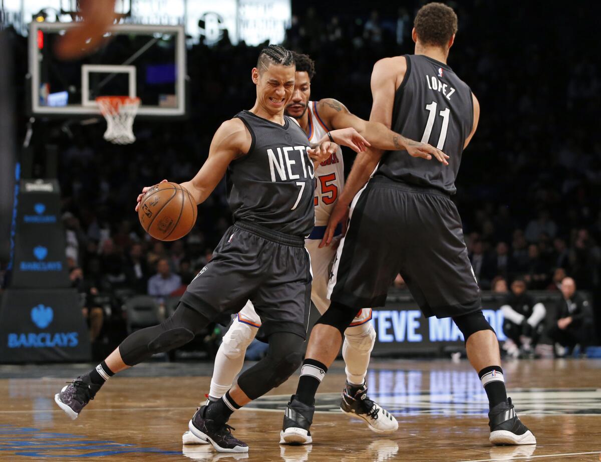 El base los Nets de Brooklyn, Jeremy Lin, aprovecha el bloqueo de Brook Lopez para deshacerse de la defensa de Derrick Rose, de los Knicks de Nueva York.