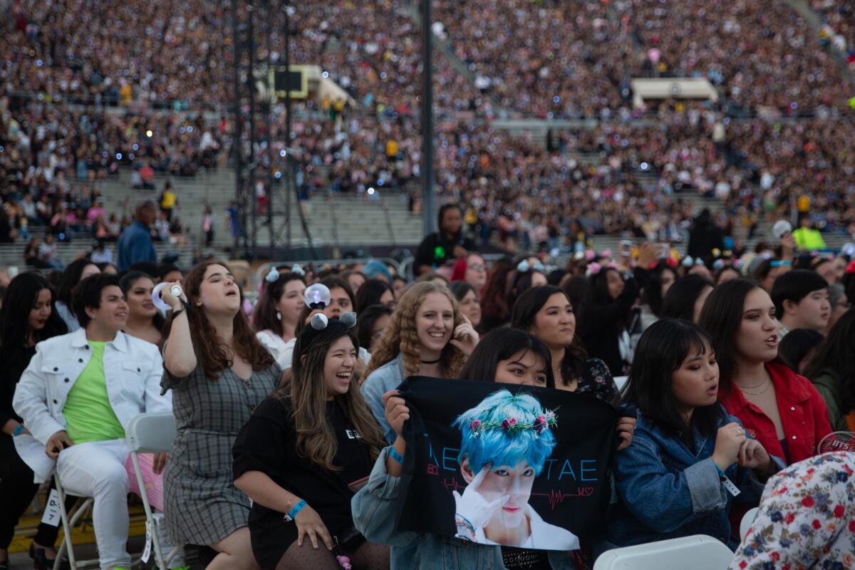 Concertgoers sit on folding chairs at the Rose Bowl in 2019