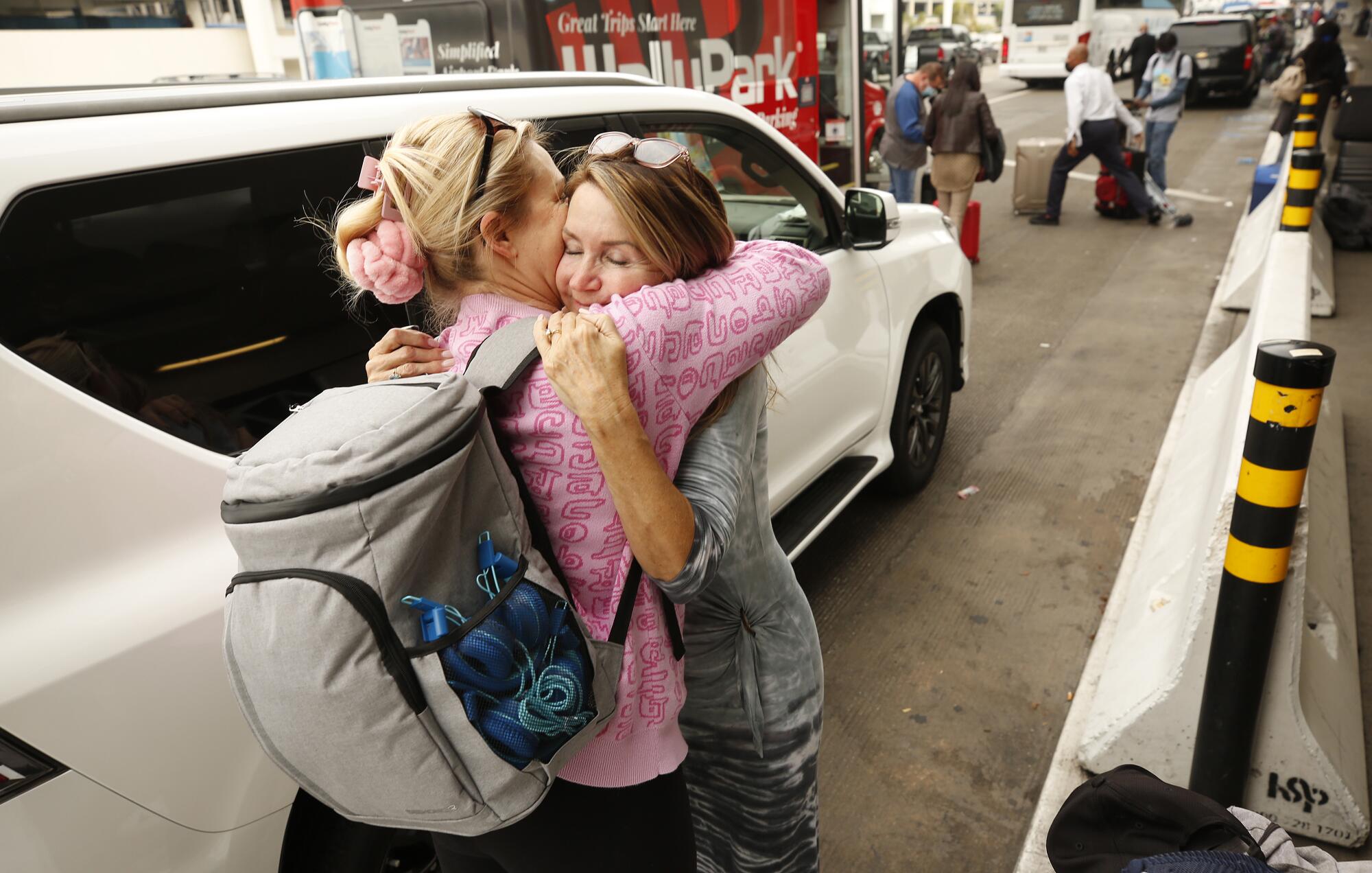 Alina Kessler, left, hugs her mother-in-law outside the airport