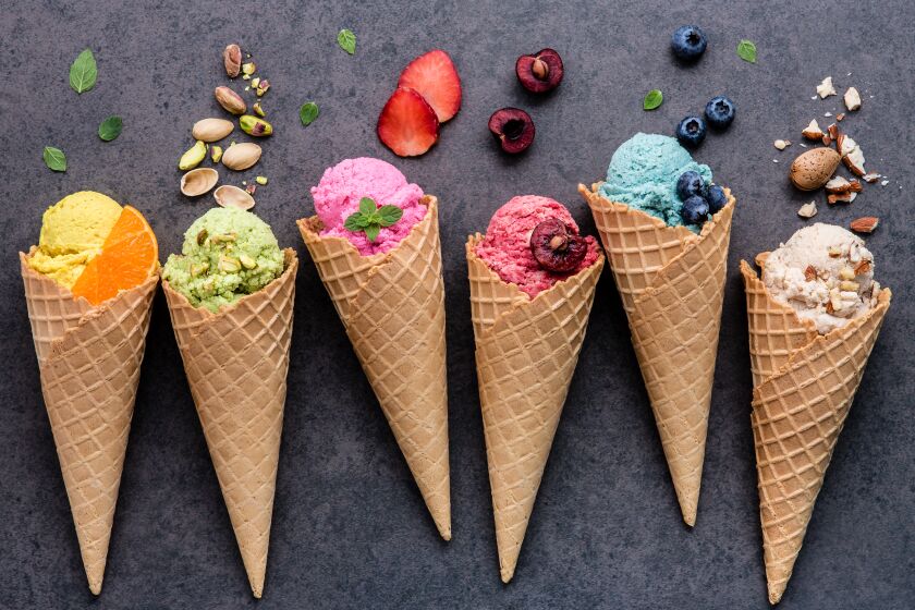 Various of ice cream flavor in cones blueberry ,strawberry ,pistachio ,almond ,orange and cherry setup on dark stone background . Summer and Sweet menu concept.