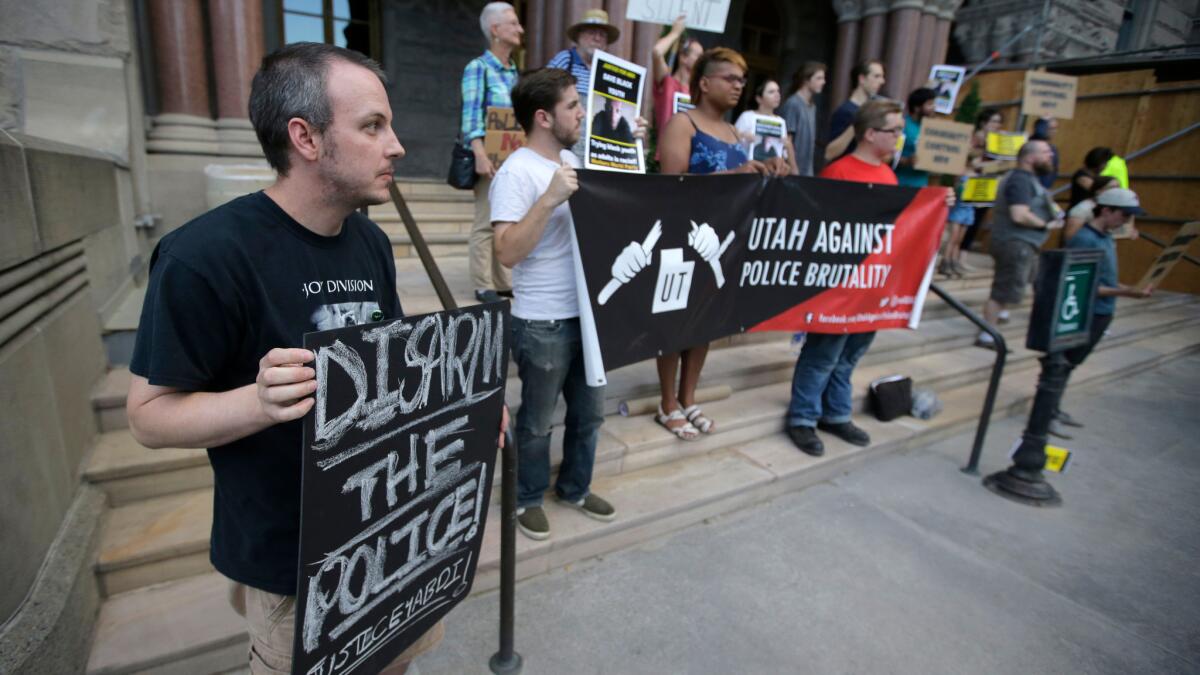 Protesters who've called for an end to police brutality demonstrate against a Utah prosecutor's decision clearing two officers in the shooting of a teen Aug. 9 in Salt Lake City.