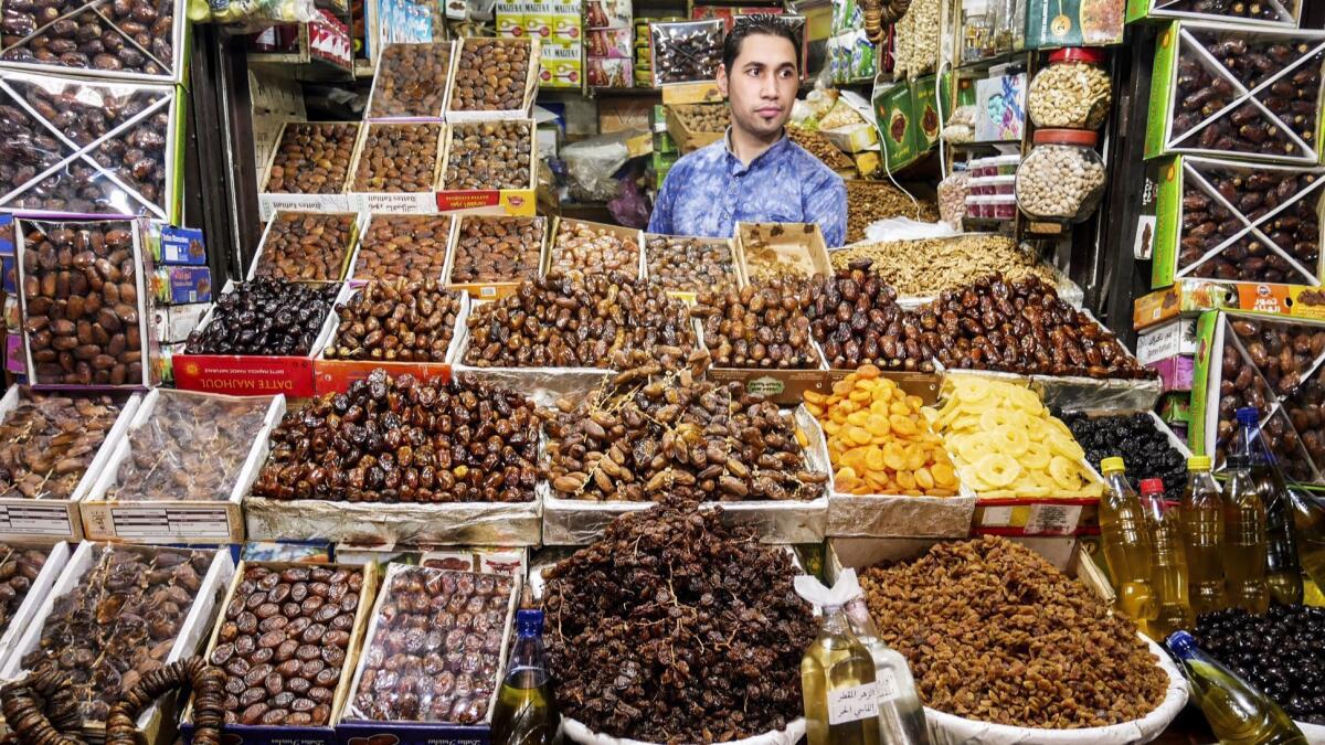 A man hawks dates and other dried fruit in one of the thousands of stalls in the souks of the ancient walled city in Fez.