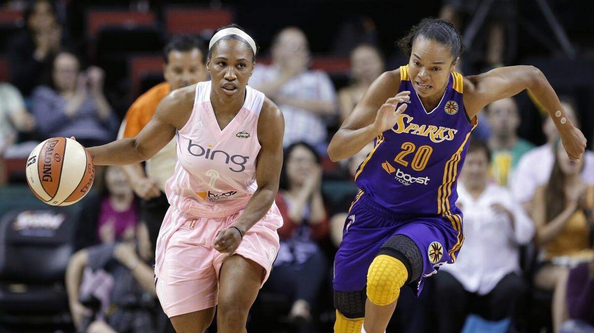 Seattle's Temeka Johnson, left, is chased by the Sparks' Kristi Toliver during the first half of the Sparks' 77-57 loss Tuesday.