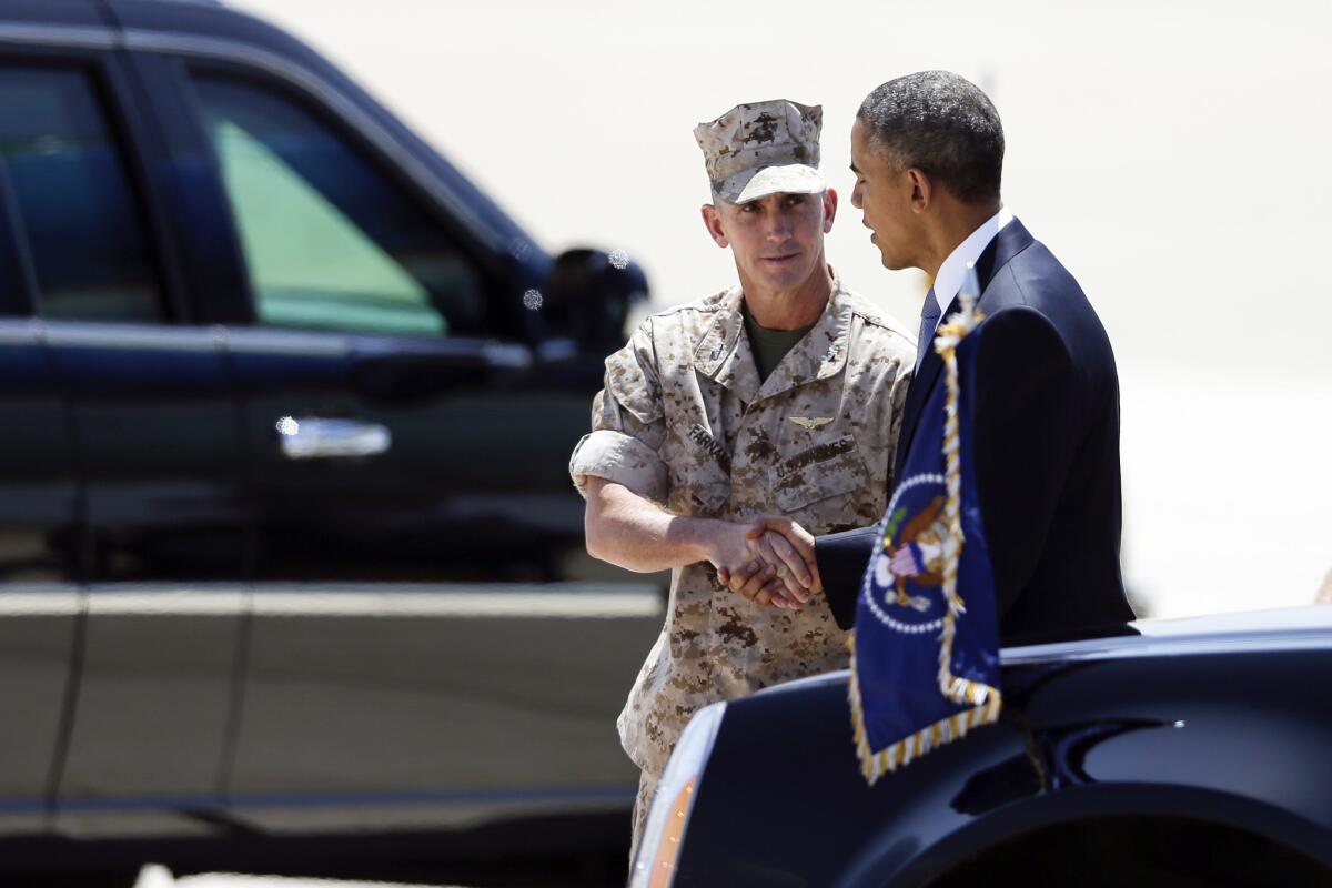President Barack Obama talks with Marine Col. John Farnam after arriving on Air Force One at Marine Corps Air Station Miramar in San Diego. Obama is set to attend a political fundraiser during his brief stopover in San Diego. Farnam is the commanding officer at Miramar.