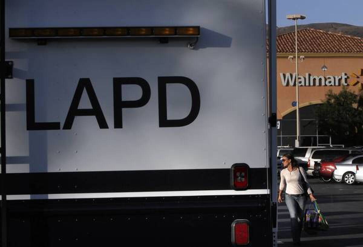 A woman walks past the LAPD's mobile command post in the parking lot at Wal-Mart in Porter Ranch. A series of violent incidents at recent Black Friday sales prompted beefed-up police deployment to control crowds of shoppers.