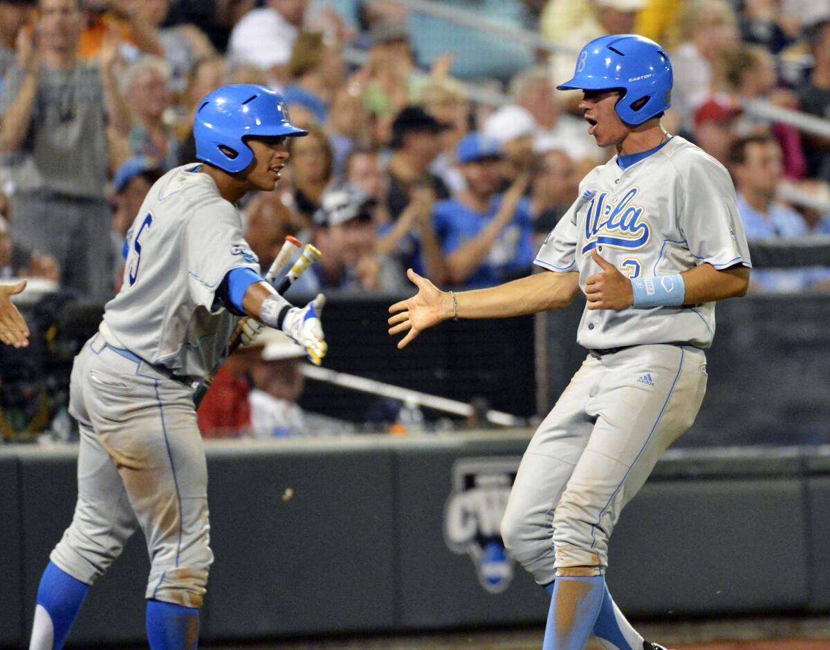 UCLA's Christoph Bono, right, is congratulated by teammate Kevin Williams after scoring the go-ahead run in a win over LSU on Sunday. The Bruins are beating opponents despite their less-than-stellar team batting average.