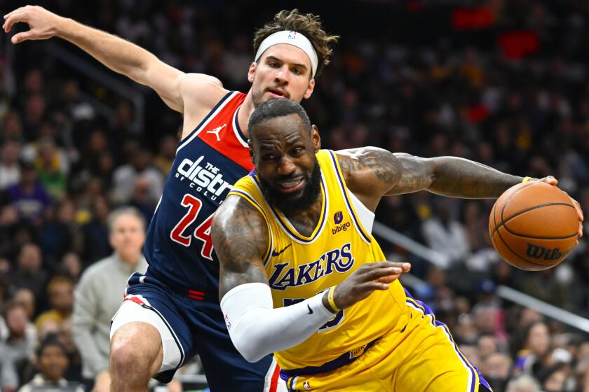 Washington Wizards forward Corey Kispert, rear, fouls Los Angeles Lakers forward LeBron James during the second half of an NBA basketball game Wednesday, April 3, 2024, in Washington. (AP Photo/John McDonnell)