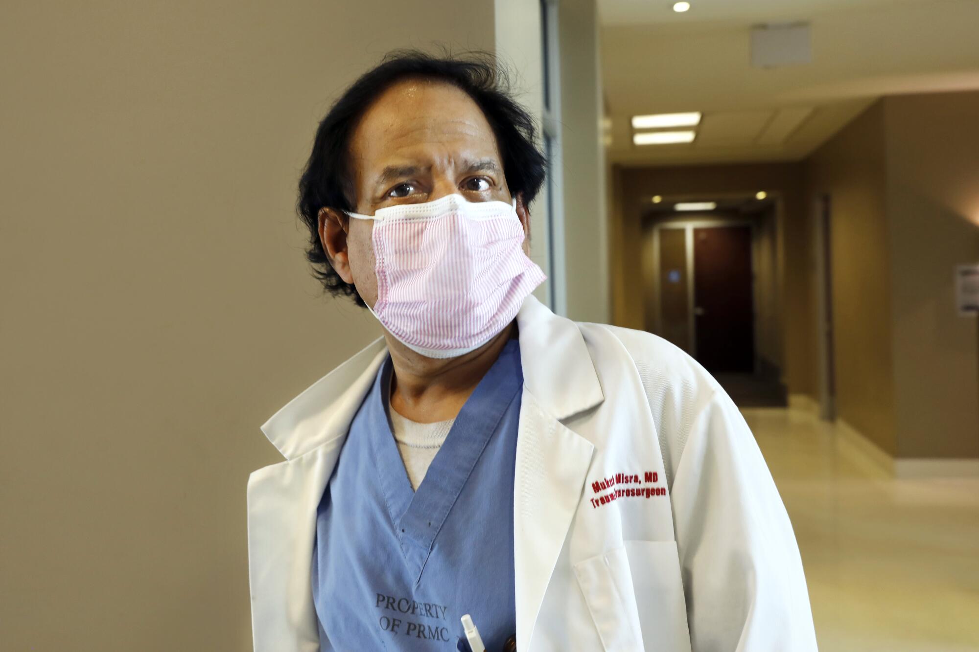 A doctor in a mask in a hospital hallway