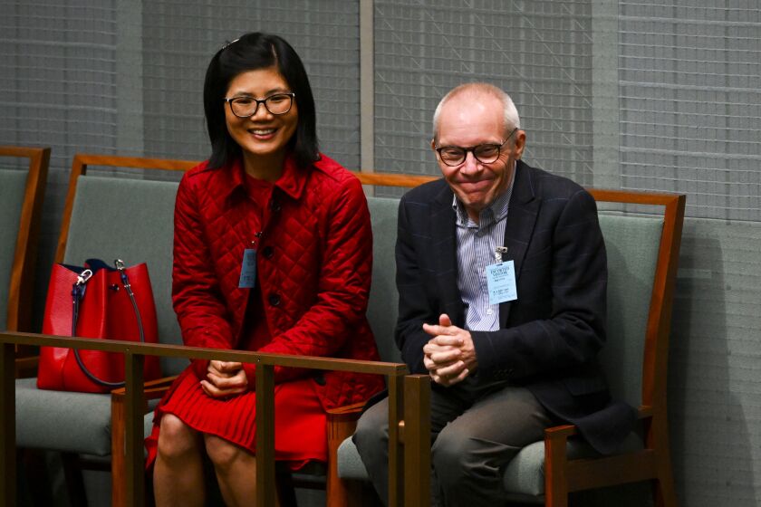 Professor Sean Turnell and his wife Dr. Ha Vu attend Question Time in the House of Representatives at Parliament House in Canberra, Australia, Thursday, Dec. 1, 2022. Turnell, an Australian economist who spent almost two years imprisoned in Myanmar, received a hero’s welcome Thursday at Australia’s Parliament House where lawmakers rose in a standing ovation and the prime minister praised his courage, optimism and resilience. (Lukas Coch/AAP Image via AP)