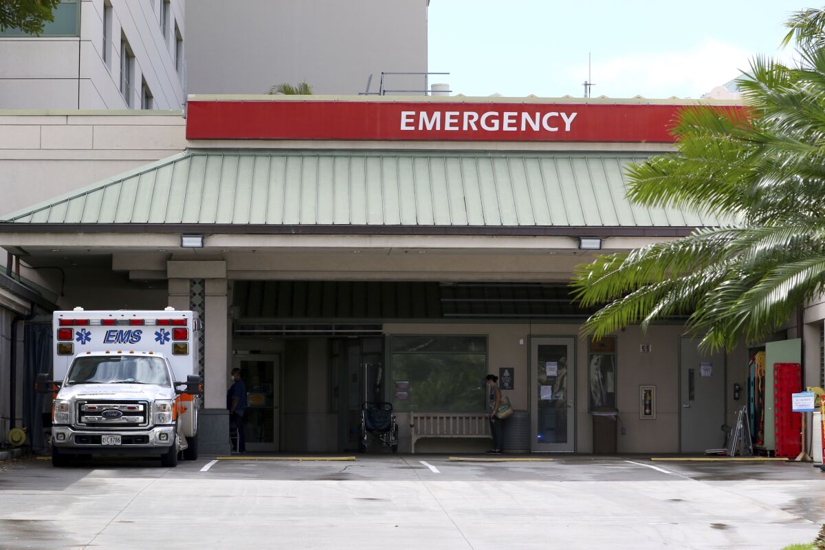 FILE — In this Aug. 24, 2021, file photo an ambulance sits outside the emergency room at The Queen's Medical Center in Honolulu. As of Jan. 1, 2022, most surprise medical bills are now banned as a result of the No Surprises Act. Surprise medical bills commonly arise when you can’t choose your provider, such as in an emergency or when you’re assigned an anesthesiologist or radiologist. (AP Photo/Caleb Jones, File)