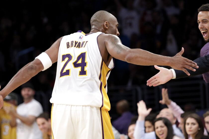 Lakers guard Kobe Bryant celebrates making a three-pointer with Anthony Sadler and Spencer Stone (extending hand), two of the three men who foiled a terrorist attack on a train in Paris, during a game Nov. 15.