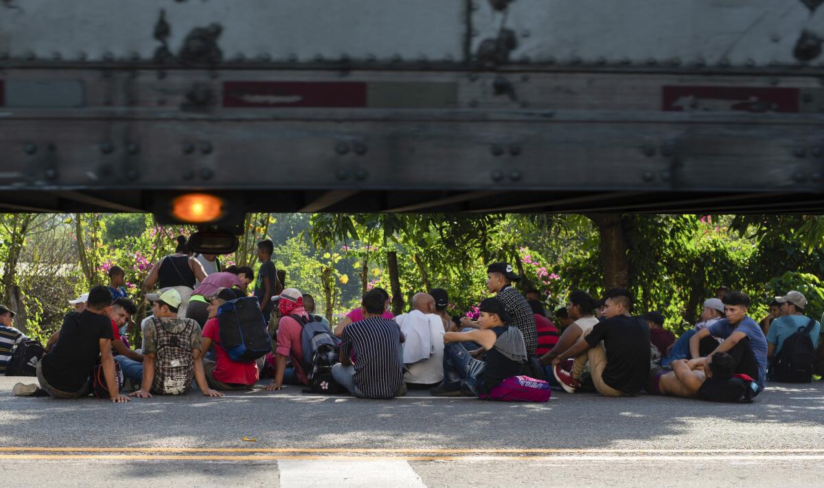 Central American migrants rest on the shoulder of a road Friday in Ciudad Hidalgo, Mexico.