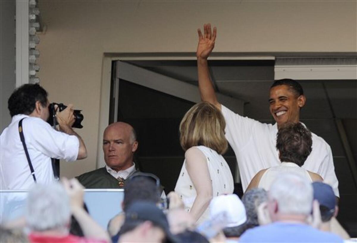 President Barack Obama, right, waves to the crowd as he attends a baseball game between the Washington Nationals and the Chicago White Sox, Friday, June 18, 2010, in Washington. (AP Photo/Nick Wass)