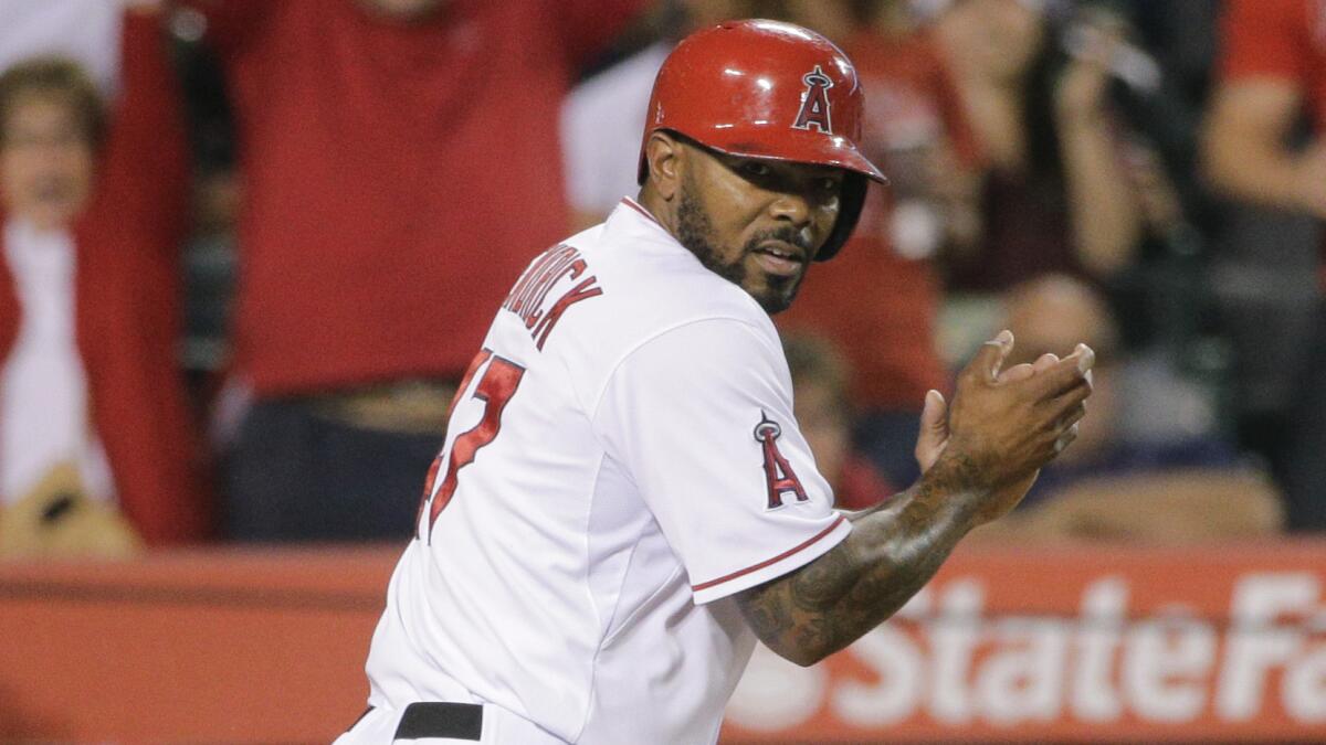 Angels second baseman Howie Kendrick celebrates after scoring on a double by David Freese during Friday's 3-2 win in 16 innings over the Seattle Mariners.