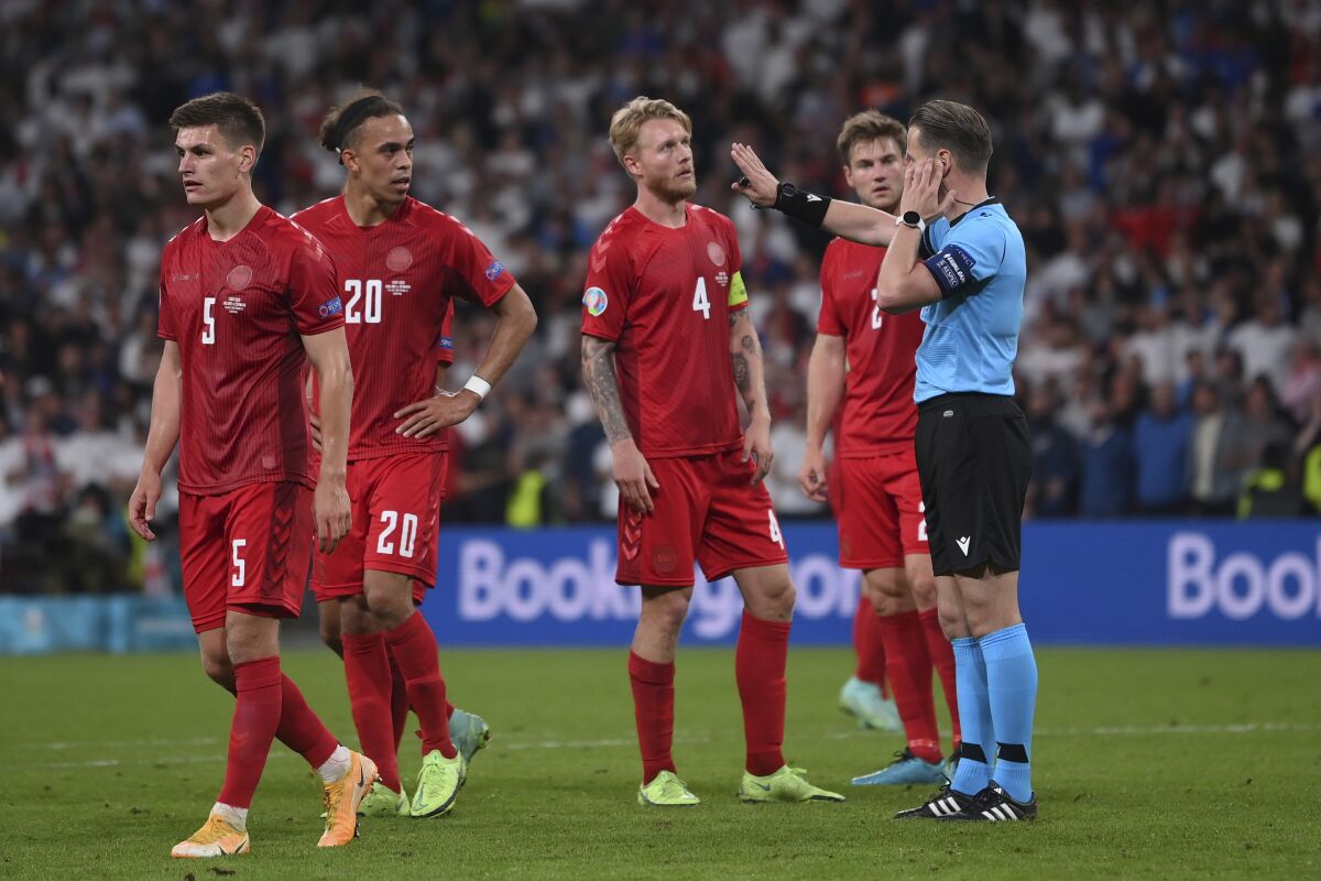 Referee Danny Makkelie checks with VAR for penalty during the Euro 2020 soccer semifinal match between England and Denmark at Wembley stadium in London, Wednesday, July 7, 2021. (Laurence Griffiths/Pool Photo via AP)