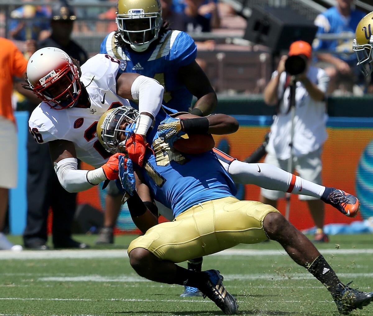 UCLA receiver Mossi Johnson hauls in a pass against the defense of Virginia cornerback Maurice Canady in the first half Saturday afternoon at the Rose Bowl.
