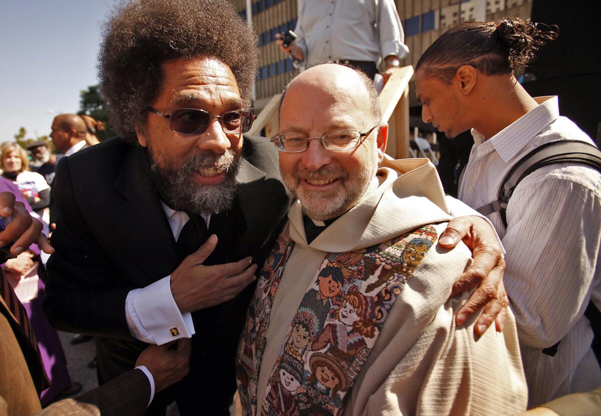 Seib, Al –– B581604708Z.1 LOS ANGELES, CA OCTOBER 07, 2011 –– Professor Cornel West, left, hugs Father Chris Ponnet, Director/Pastor of the St. Camillus Catholic Center for Pastoral Care, right, after speaking at a Interfaith Communities United for Justice and Peace rally that blocked Los Angeles Street Friday morning. The ICUJP marked the 10th anniversary of the US war in Afghanistan with the protest that started at La Placita Church and a march past city hall ending with a rally at the downtown Federal Building where 15 protestors were arrested by the LAPD.(Al Seib / Los Angeles Times)