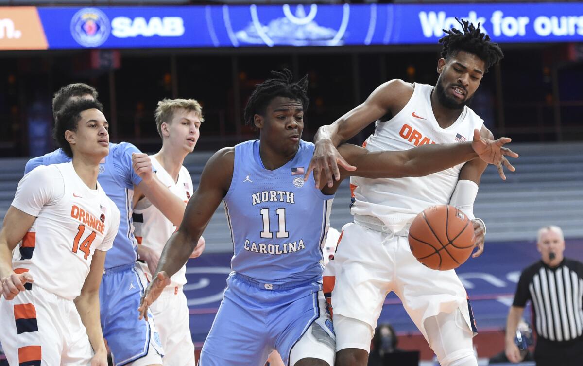 North Carolina forward Day'Ron Sharpe (11) and Syracuse forward Quincy Guerrier (1) work on getting the ball during an NCAA college basketball game in Syracuse, N.Y., Monday, March 1, 2021. (Dennis Nett/The Post-Standard via AP)