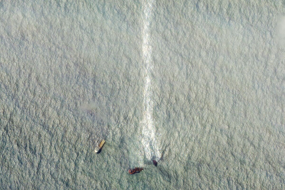 This satellite image provided by Planet Labs Inc. shows a sinking ship, the Singapore-flagged MV X-Press Pearl, with the oil leak line in the Laccadive Sea off Sri Lanka Monday, June 7, 2021. (Planet Labs Inc. via AP)