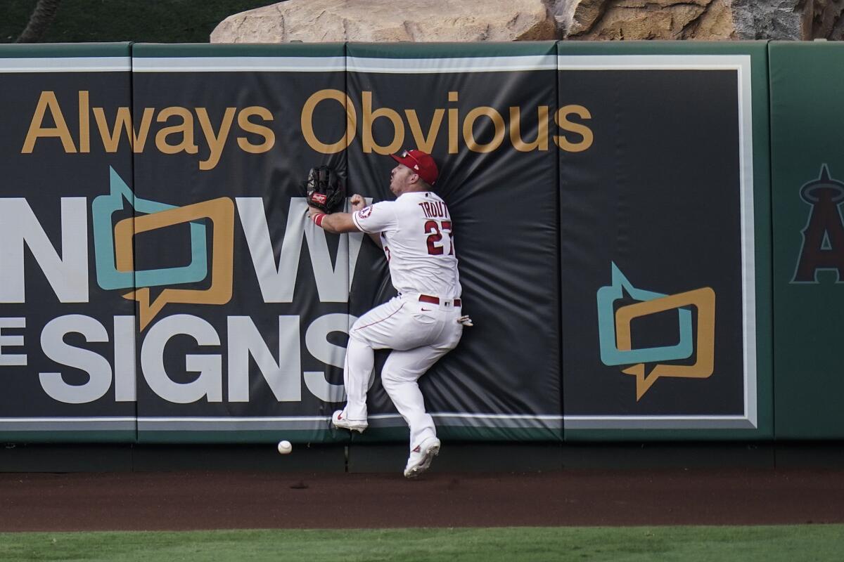 Angels' Mike Trout collides with the wall while trying to catch a triple.
