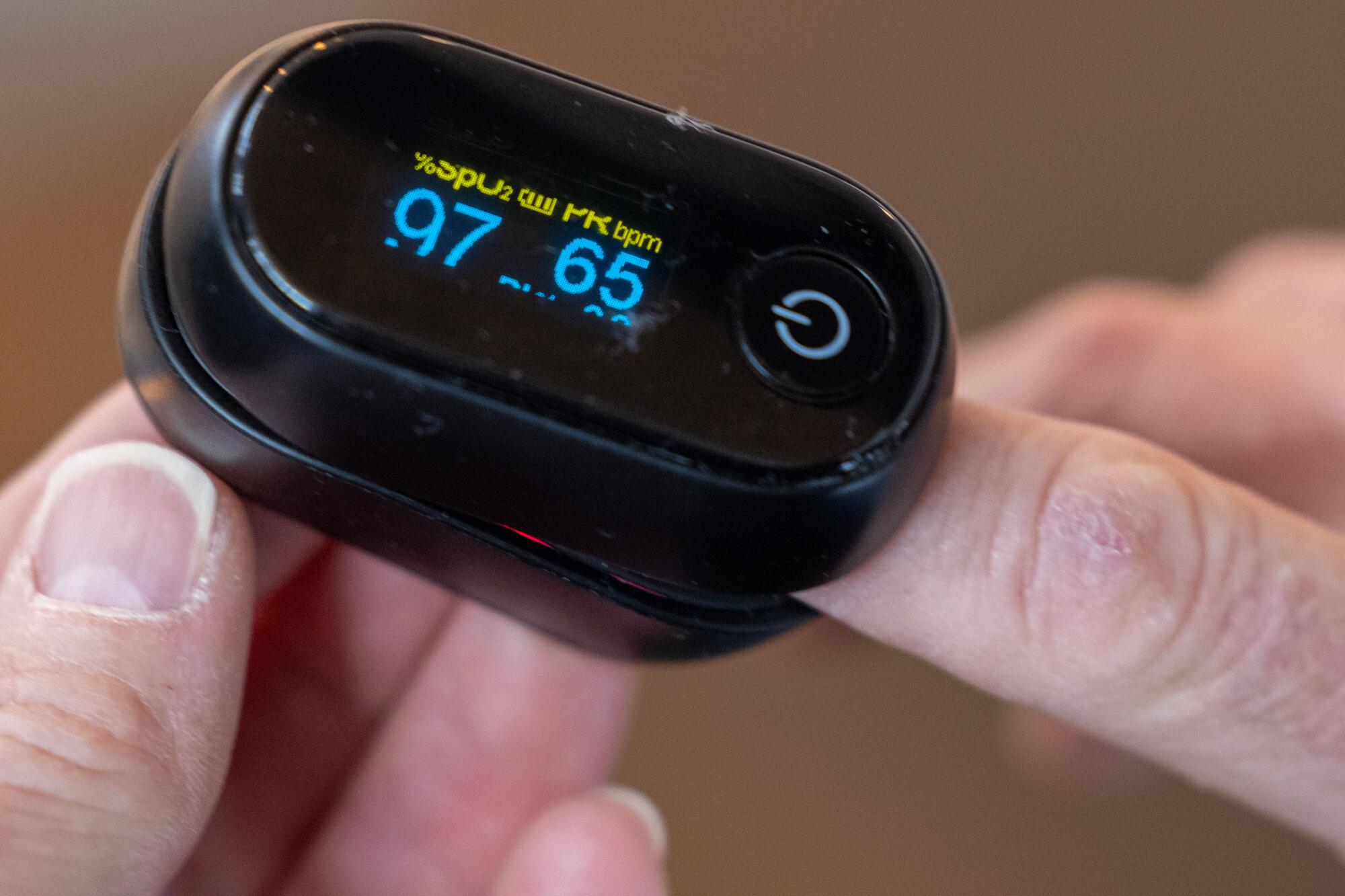 A close-up view of a pulse oximeter on a person's finger.