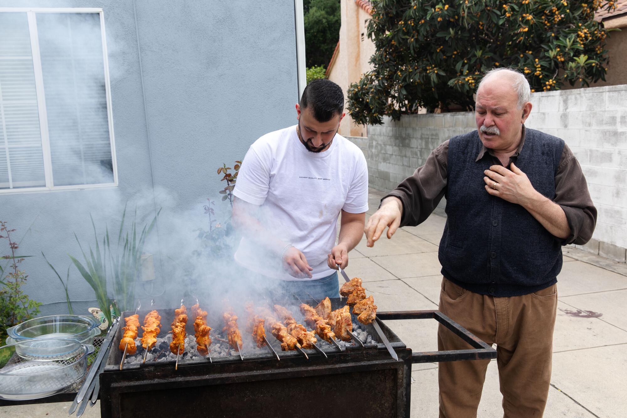 Alex Khachoyan and son Harout work the grill at Alex's home.