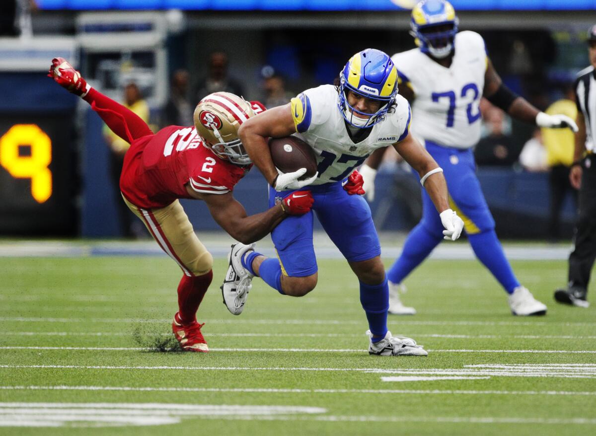 Rams receiver Puka Nacua runs after making one of his 15 catches against the 49ers as Deommodore Lenoir attempts to tackle.