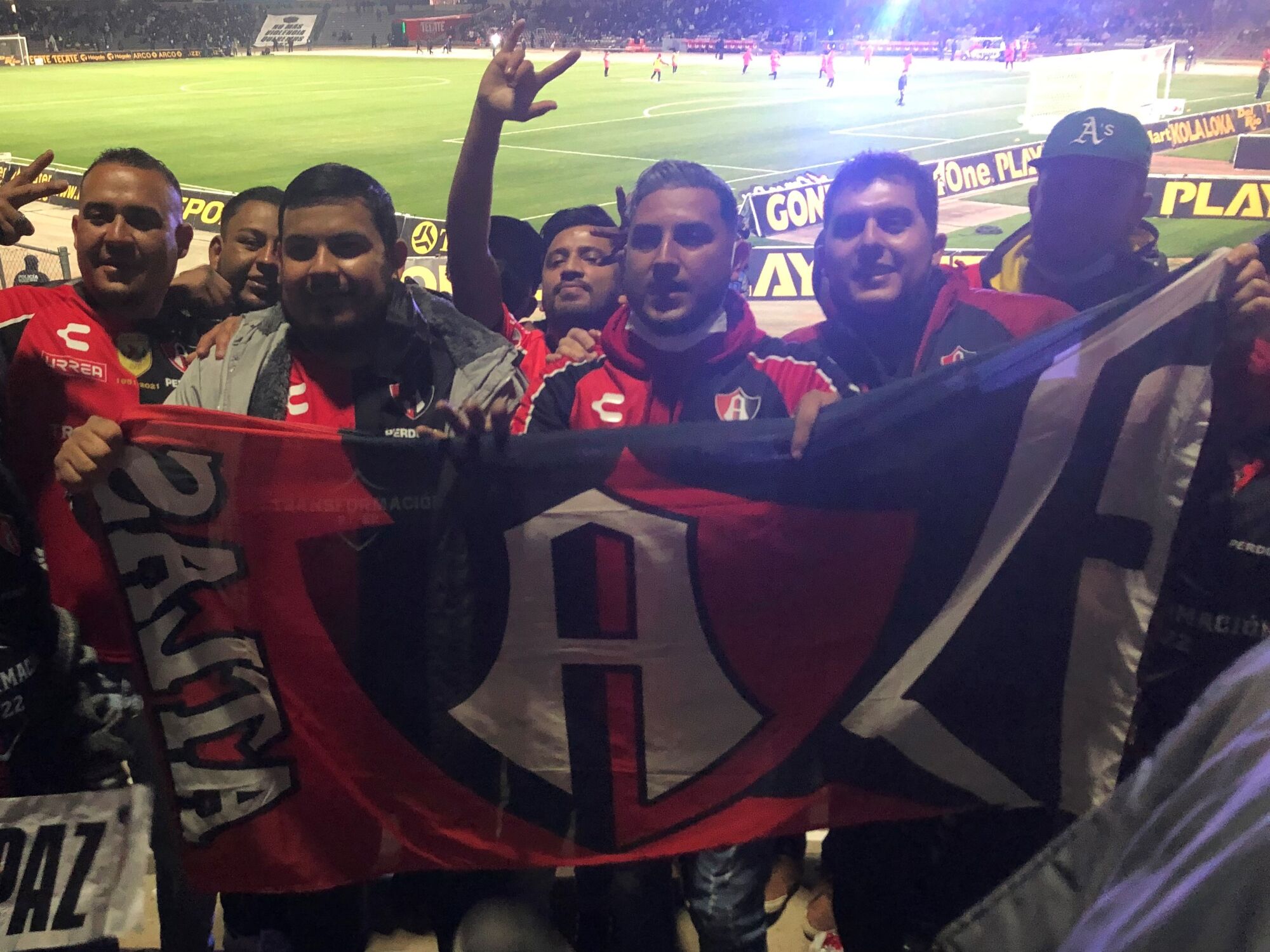 Atlas fans hold up a team flag and cheer during a match against FC Juárez on Friday.