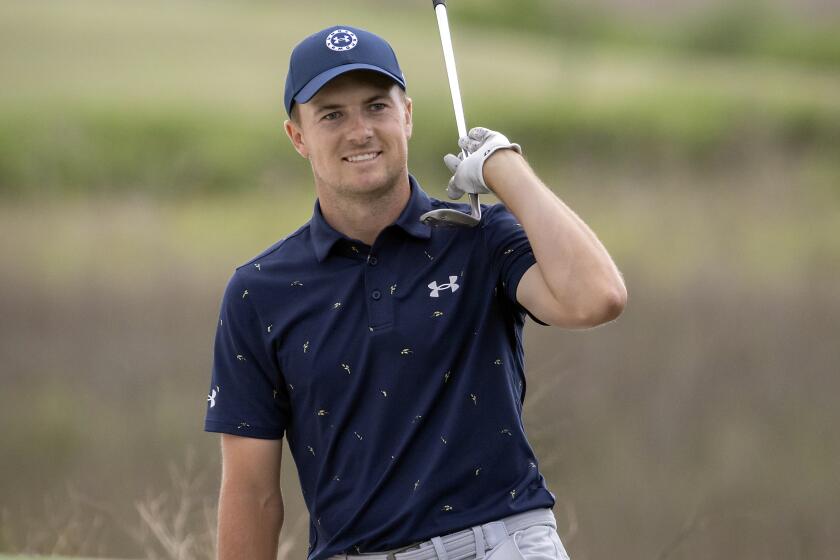 Jordan Spieth celebrates from the front bunker after chipping in at the 18th hole.