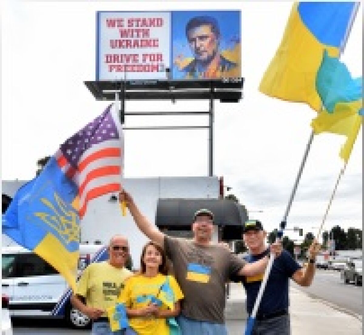 A billboard promoting a campaign for U.S. unity with Ukraine is celebrated after it was erected on Midway Drive.