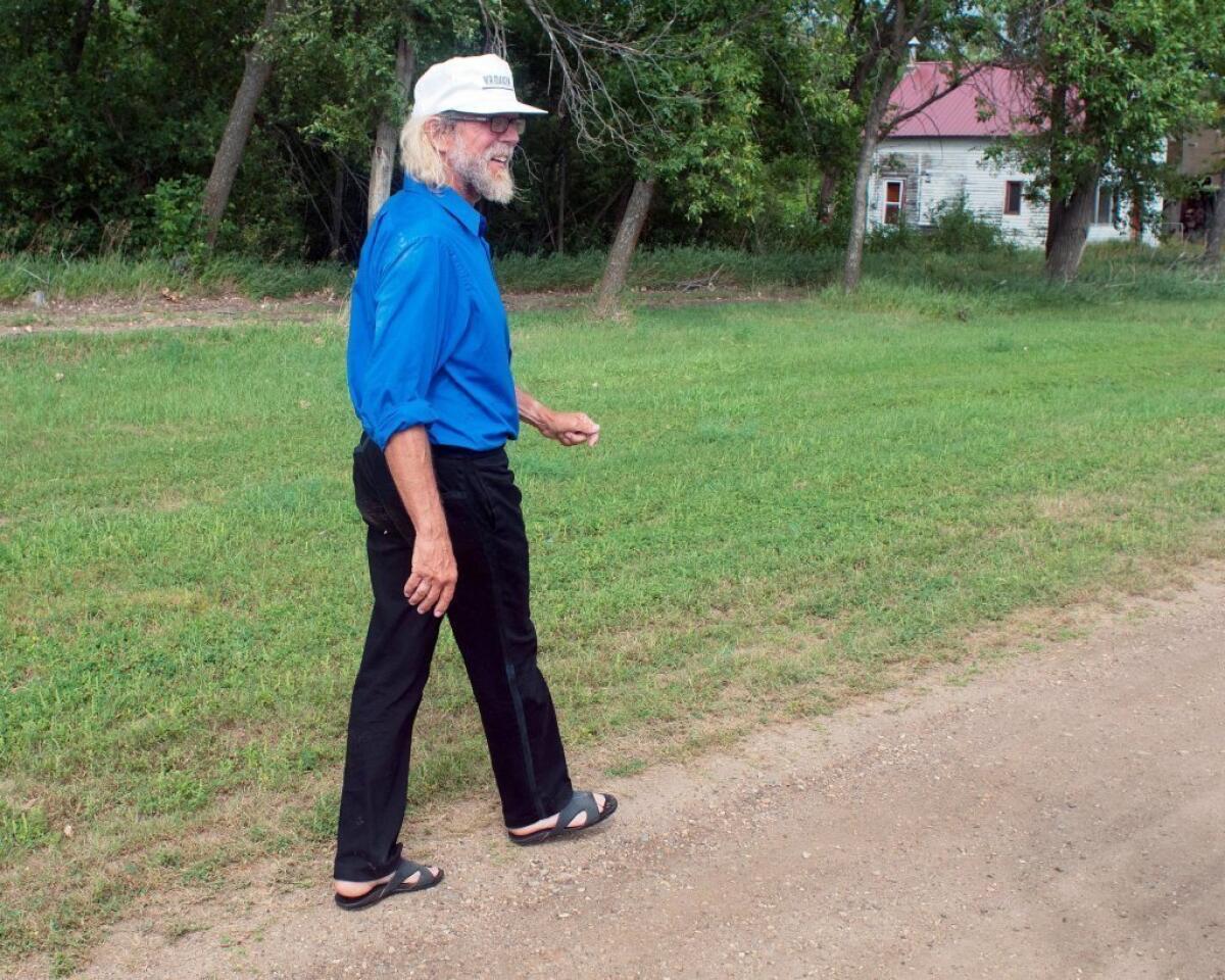 White supremacist Craig Cobb walks along Main Street toward his home in Leith, N.D., last month. Cobb, 61, has purchased more than a dozen lots in Leith and over the last year he has invited fellow supremacists to move there and help him to transform the town of 16 people into a white enclave.