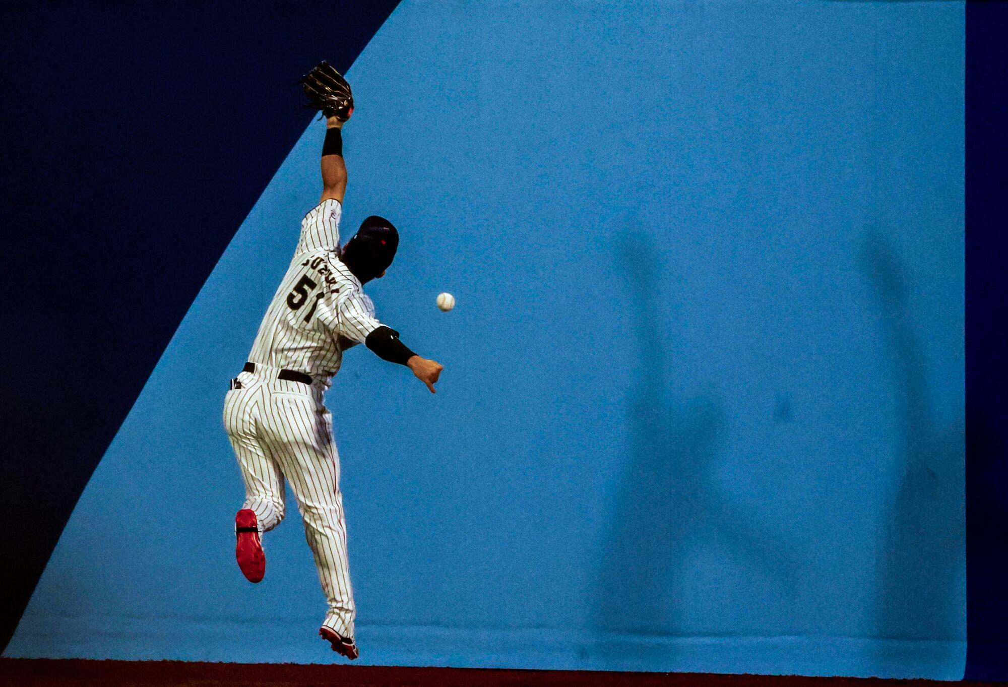 Team Japan outfielder Seiya Suzuki (51) can't catch up to double hit by Team South Korea outfielder Jung Hoo Lee (51)