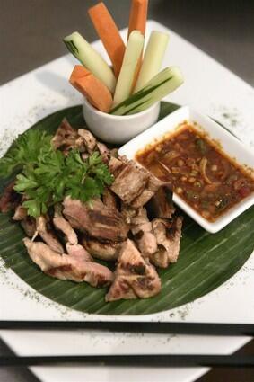 Bangkok BBQ Pork, charred marinated pork with spicy sauce, at Nakkara Thai on Beverly Boulevard in Los Angeles.