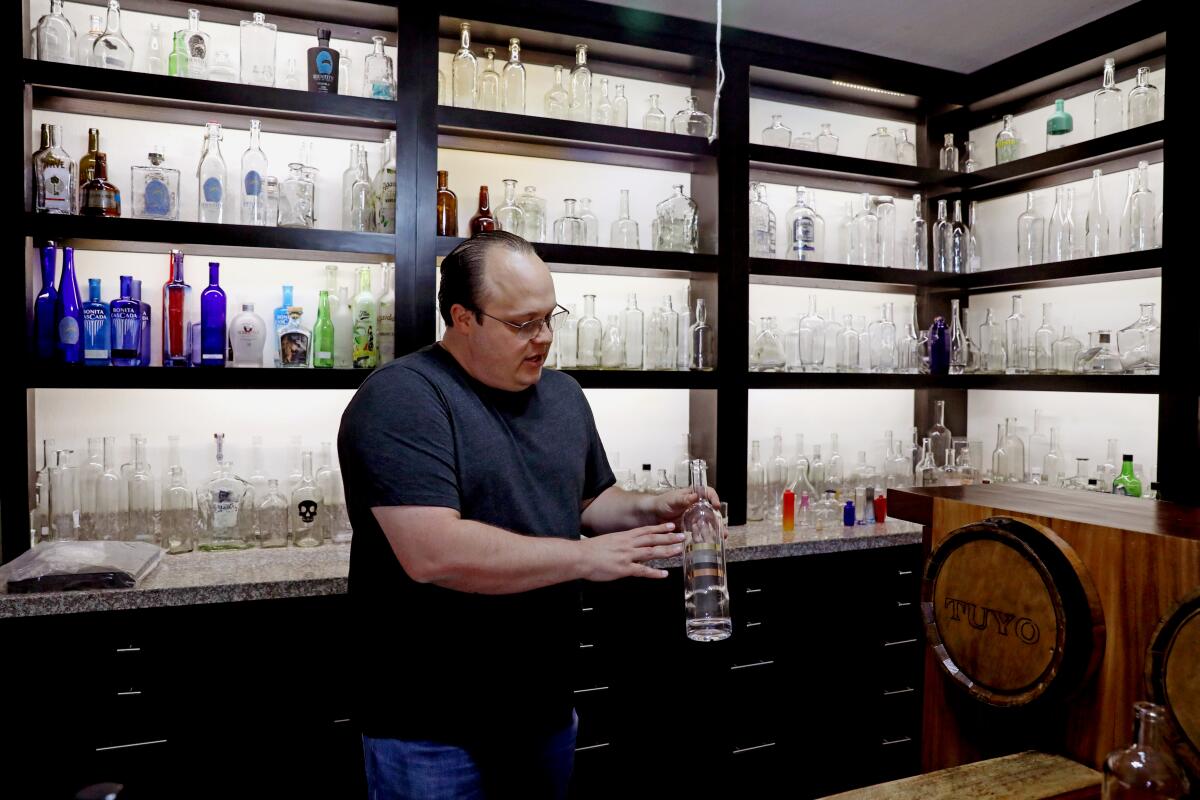 Mario Villanueva displays a glass bottle at Casa Maestri tequila distillery.