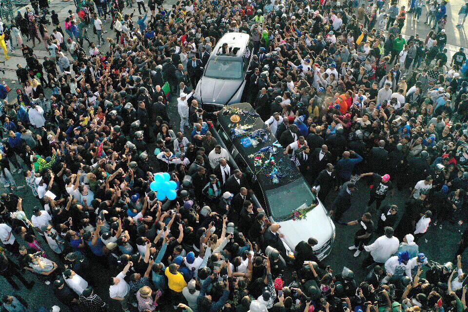 A hearse carrying the casket of Nipsey Hussle drives through a huge throng near his clothing store on Slauson Avenue in South Los Angeles.