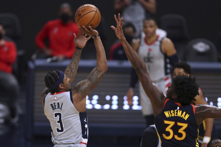 Washington Wizards forward Bradley Beal, left, shoots against Golden State Warriors center James Wiseman during the first half of an NBA basketball game in San Francisco, Friday, April 9, 2021. (AP Photo/Jed Jacobsohn)