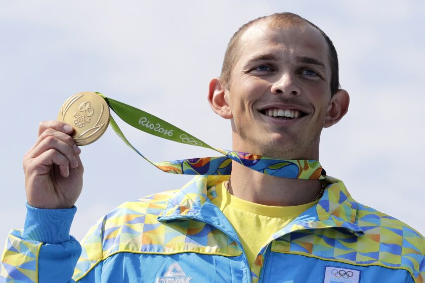 FILE - Ukraine's Yuri Cheban celebrates his gold medal in the men's canoe single 200m final during the 2016 Summer Olympics in Rio de Janeiro on Aug. 18, 2016. Cheban, one of Ukraine's most decorated Olympians, told The Associated Press in an email exchange Wednesday, Nov. 30, 2022, that he is auctioning his medals — two golds and a bronze — in hopes of raising a six-figure donation to contribute to the war effort in his native land. (AP Photo/Matt York, File)