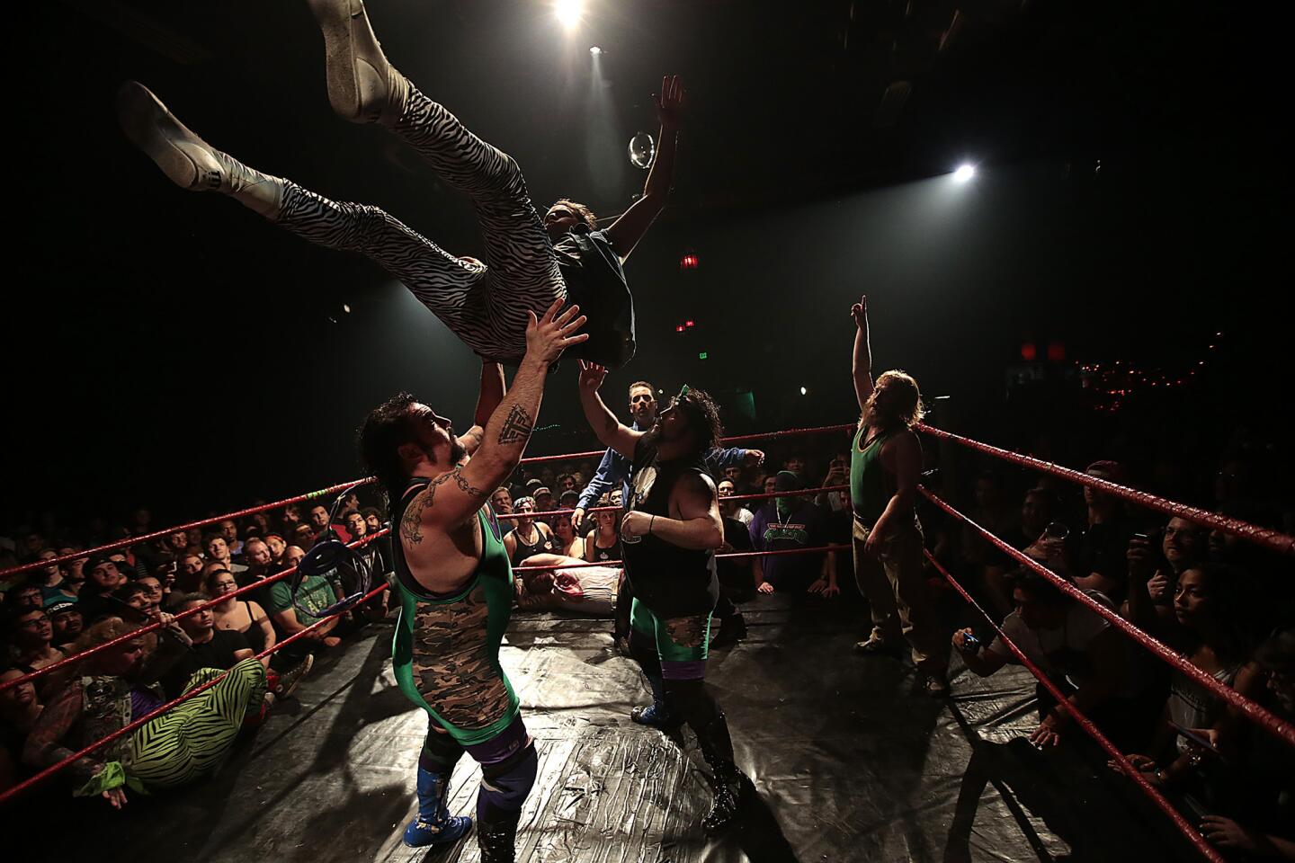 A Hoodslam tag-team match pits the Stoner Brothers (Dustin, left, and Derek Mehl) and Sledge & the Lovefisters (Toby Reynolds, top) at the Oakland Metro Opera House.