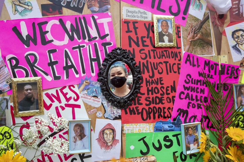 Sierra Hood is reflected in a mirror on her "Pray for the Hood" in Leimert Park.