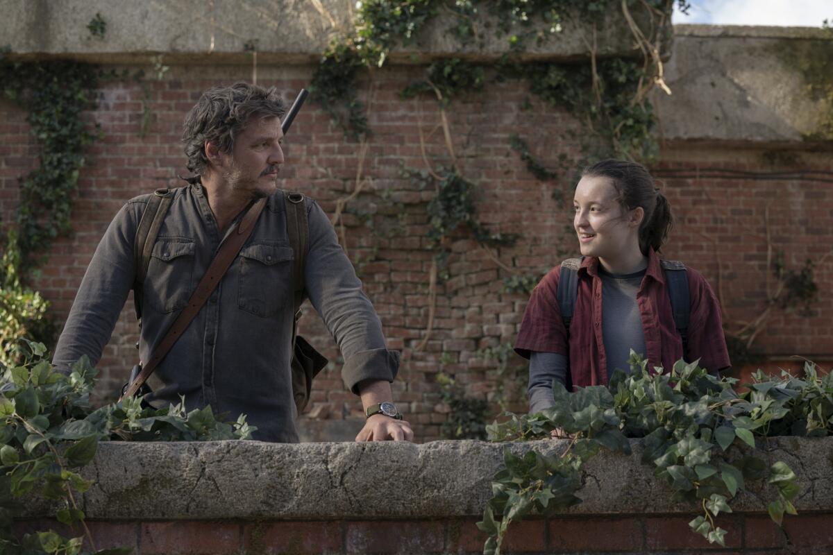 A man and a teenage girl smiling at each other on a rooftop.