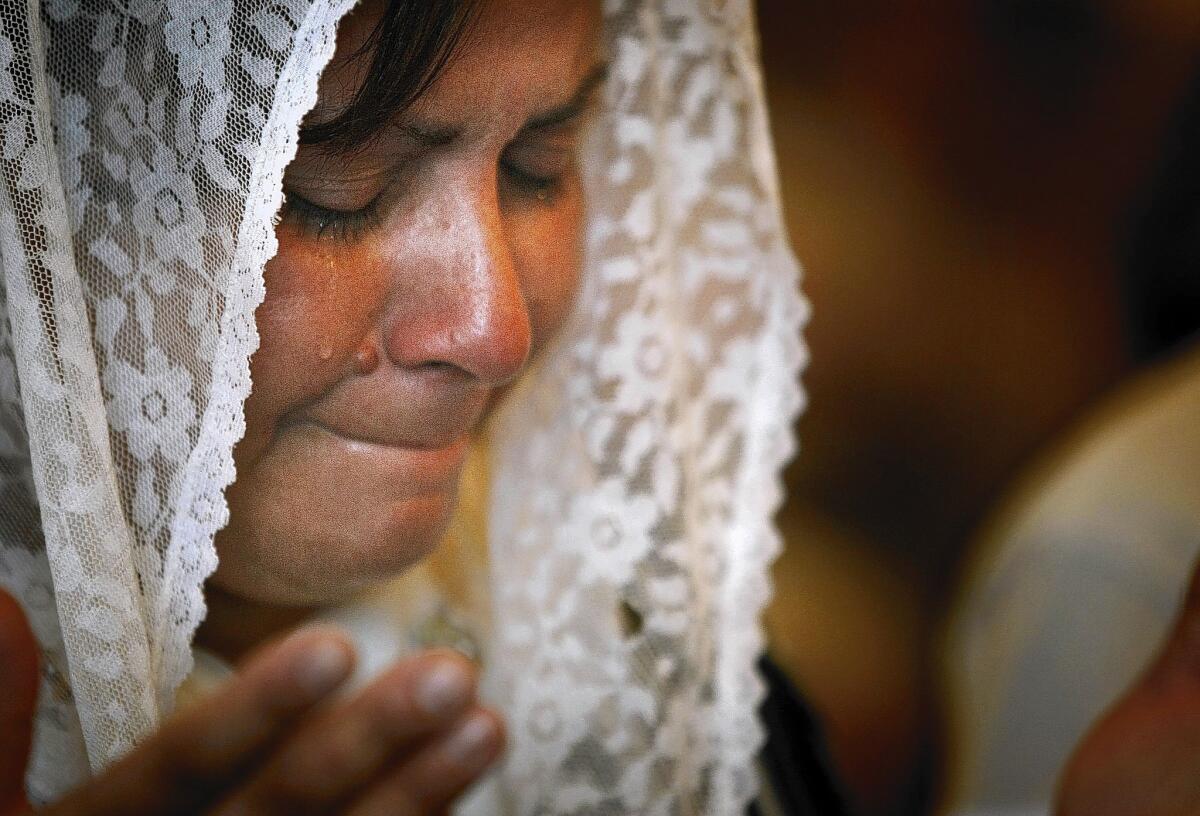 A woman who recently fled the escalating violence in Iraq sheds a tear during Sunday Mass at Our Mother of Perpetual Help Syriac Catholic Church in El Cajon, Calif. "My wife is crying for the people left behind," her husband says.