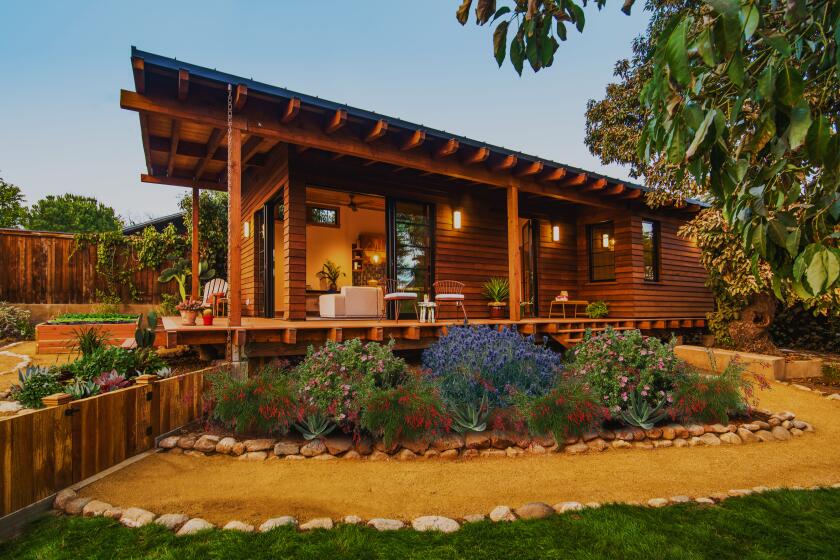 An exterior shot of an ADU with wood siding and a wrap-around deck