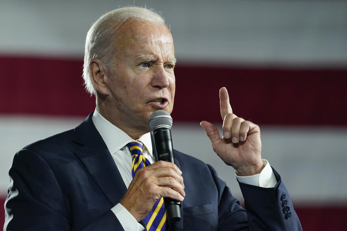 President  Biden speaks into a microphone 