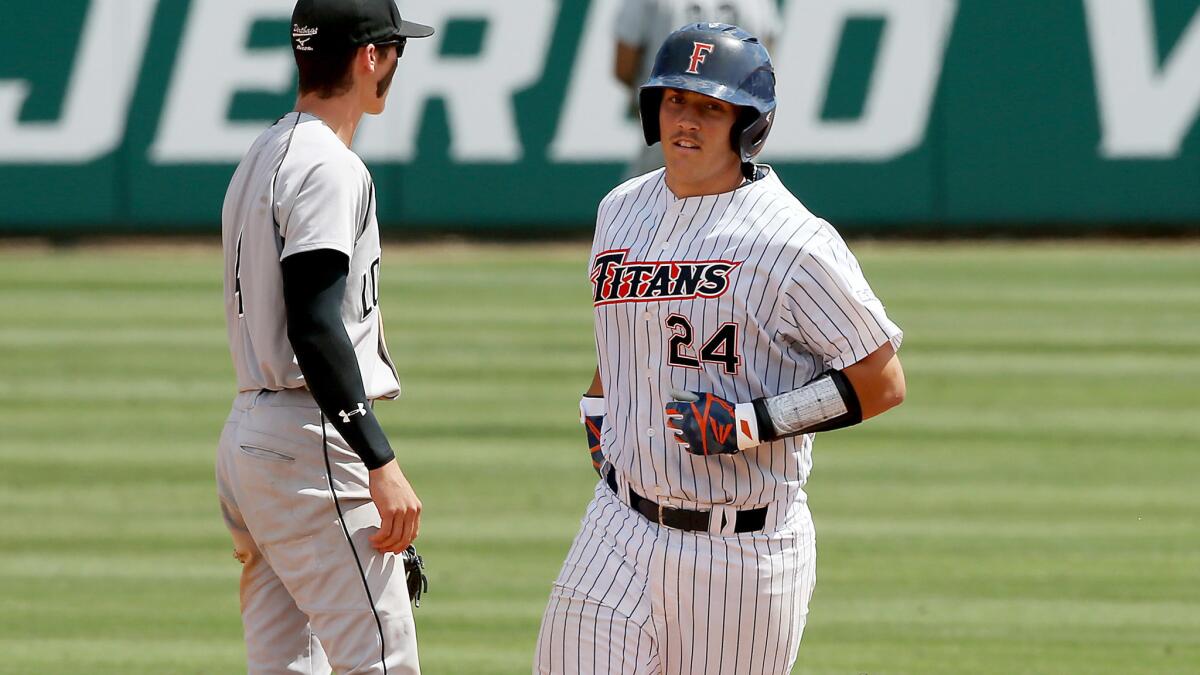 Fullerton catcher Chris Hudgins rounds the bases after hitting a two-run home run against Long Beach State during the eighth inning Saturday.