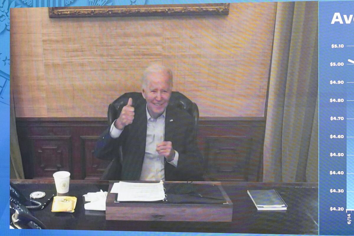 President Biden sitting at a desk and giving a thumbs-up in an image from a video meeting. 