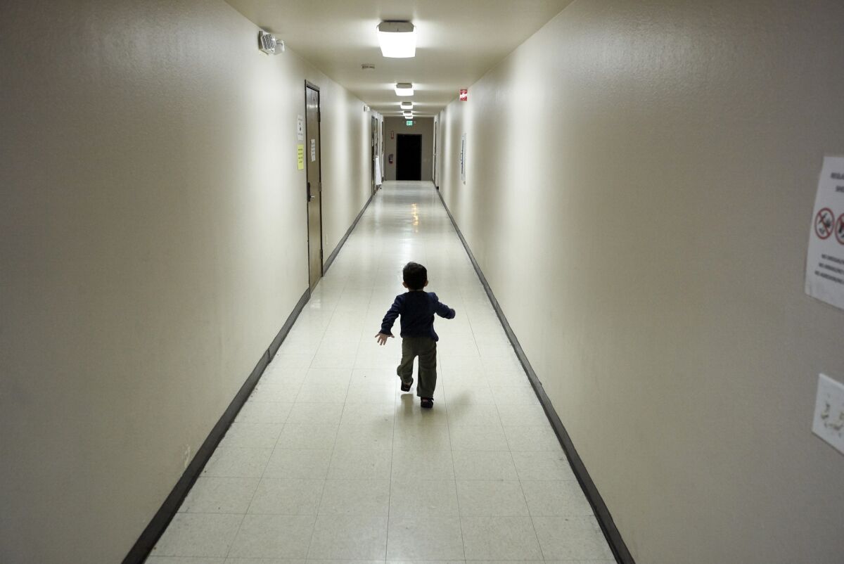 An asylum-seeking boy from Central America runs down a hallway at immigration detention center