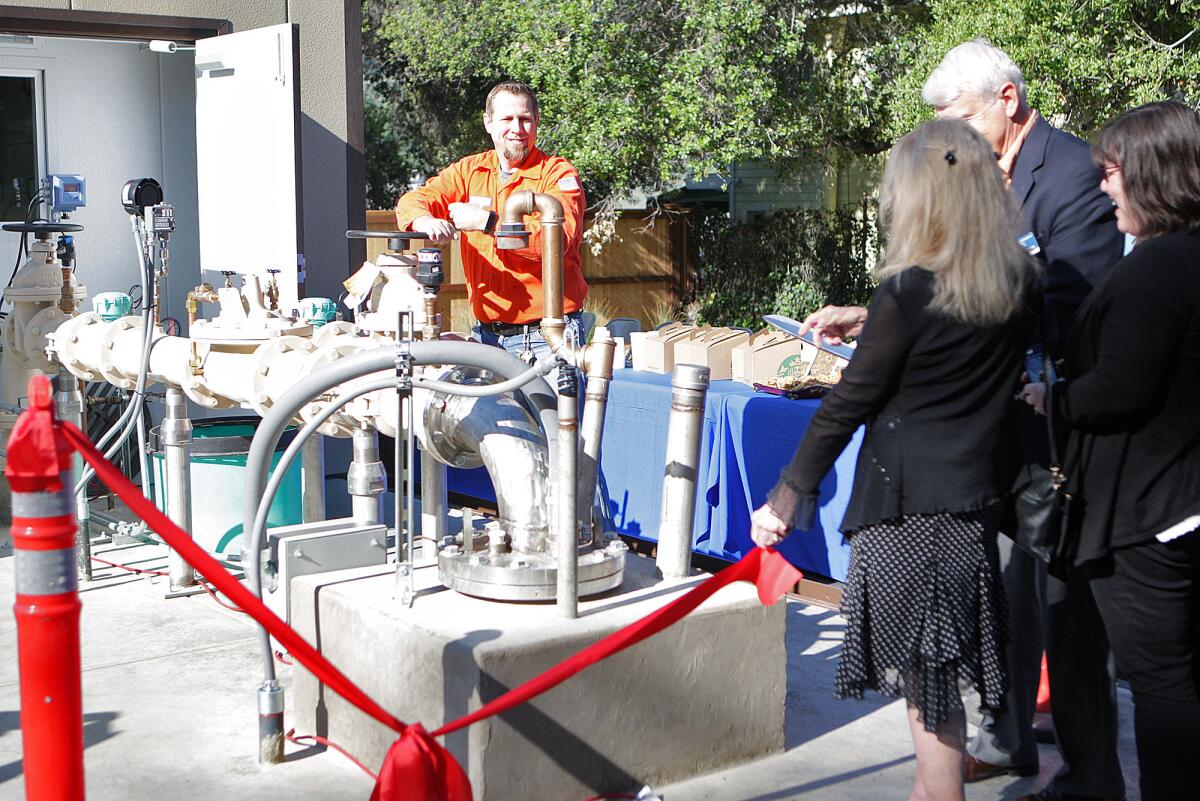 As the ribbon is cut by the Crescenta Valley City Council, Morgen Durose turns a valve to show the flow of water being pulled from the ground into the pumping station during the dedication at the former Rockhaven Sanitarium in Montrose on Friday, March 18, 2016.