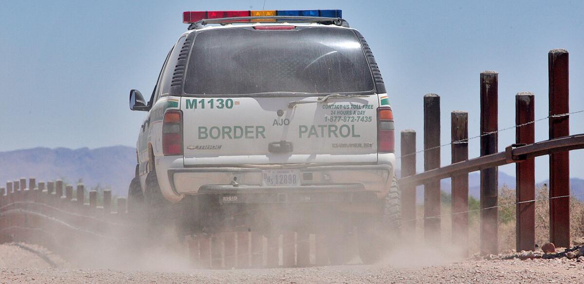 A U.S. Border Patrol agent patrols the border separating Sonoyta, Mexico, right of fence, and Lukeville, Ariz., on May 24, 2006.