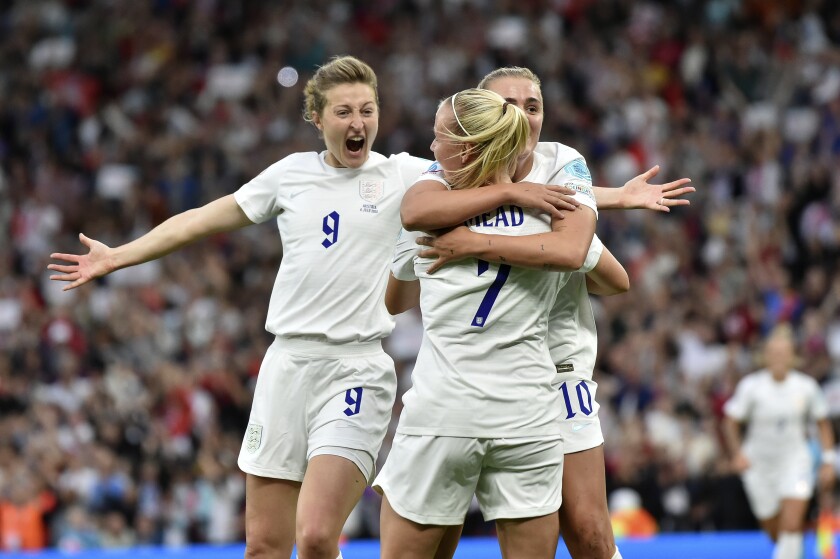 England's Beth Mead, center, celebrates with Ellen White, left, and Georgia Stanway after scoring the opening goal during the Women Euro 2022 soccer match between England and Austria at Old Trafford in Manchester, England, Wednesday, July 6, 2022. (AP Photo/Rui Vieira)