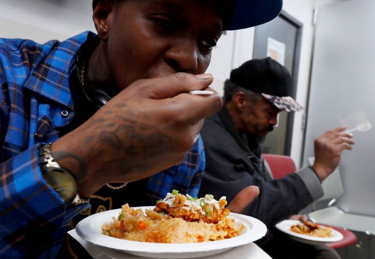 Cobb Apartments resident Itali, 33, eats an enchilada casserole following a cooking demonstration.